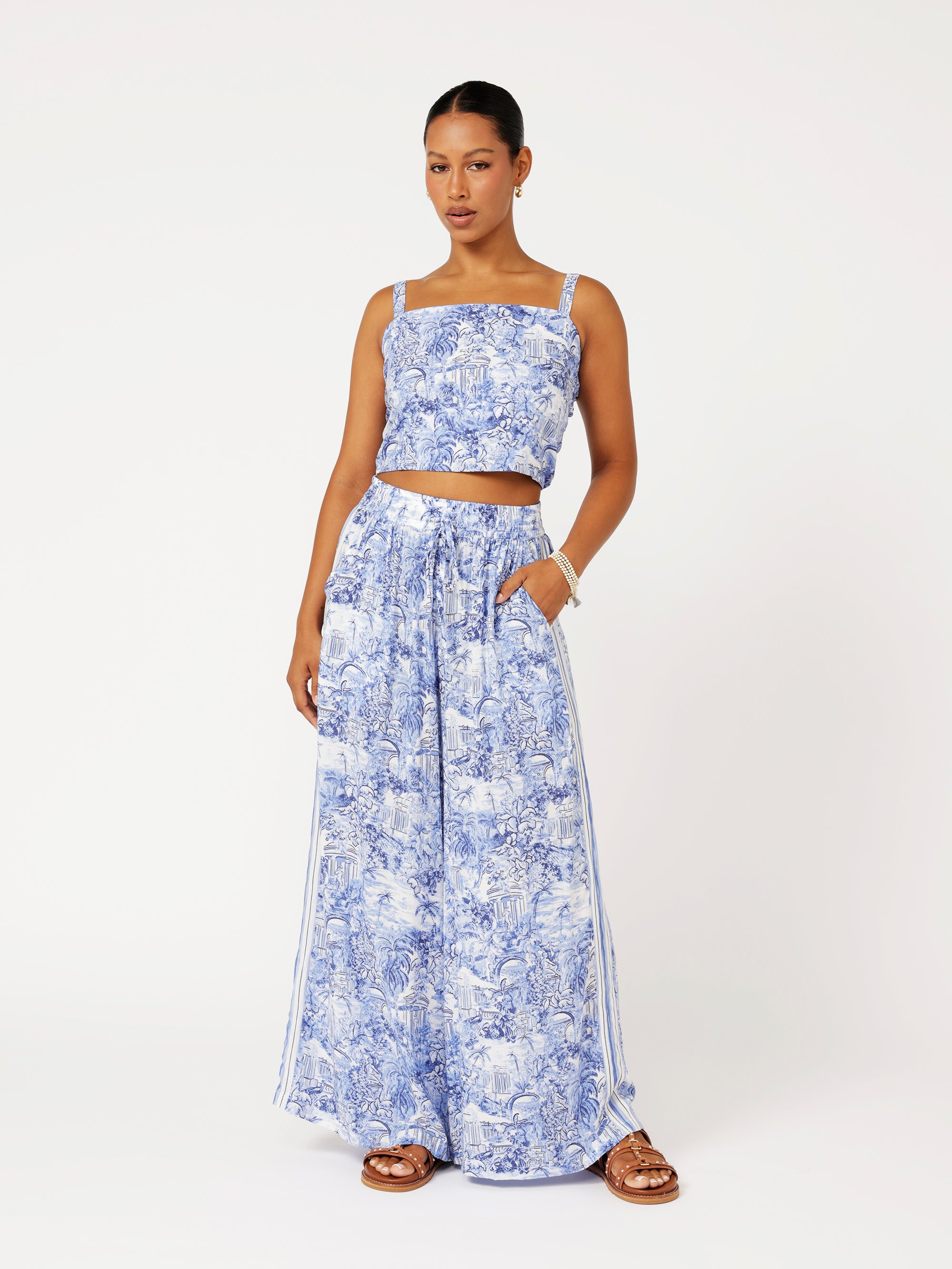 Front view of model wearing the Lost City Palazzo Pants in blue Toile de Jouy rayon print with contrast side stripe
