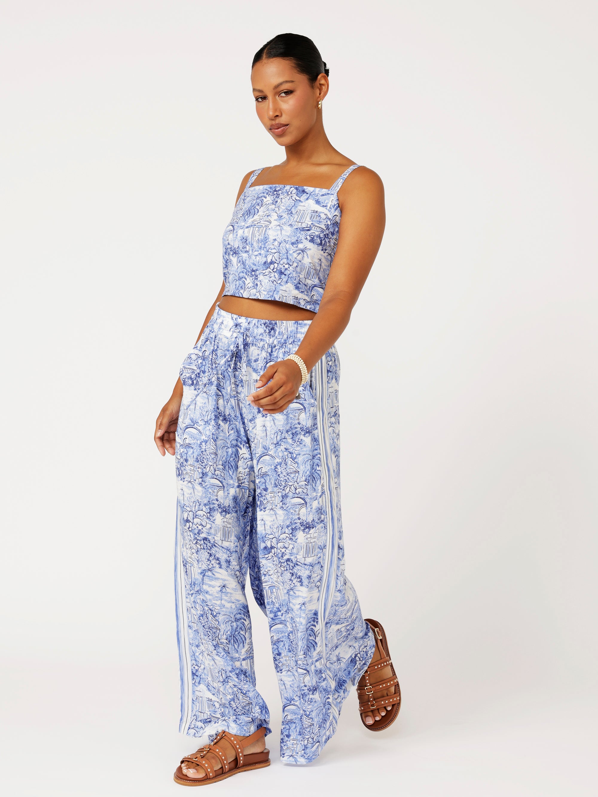 Front view of model wearing the Lost City Palazzo Pants in blue Toile de Jouy rayon print with contrast side stripe