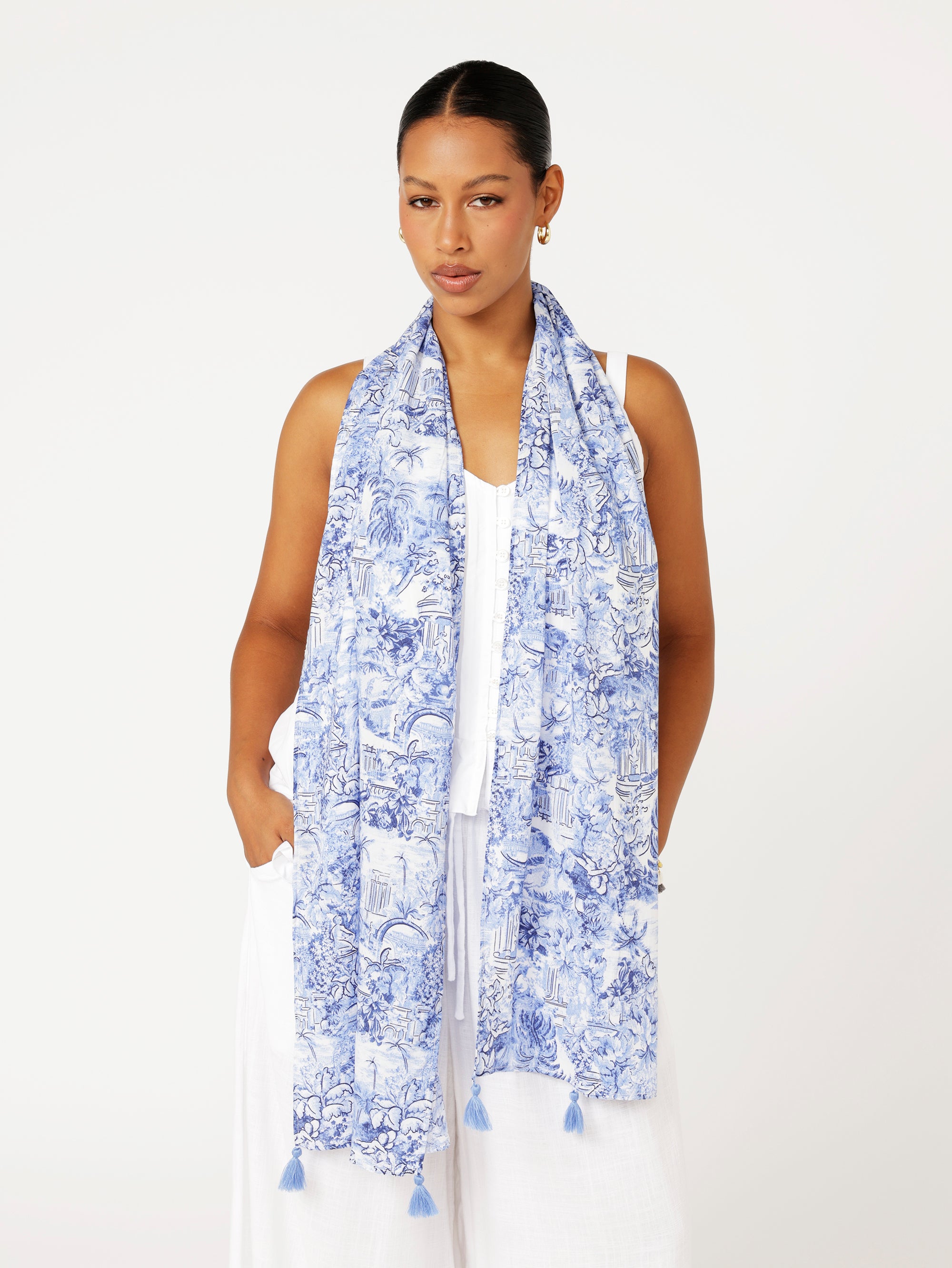 Front view of model wearing Lost City Blue Toile de Jouy rayon scarf draped loosely over white outfit