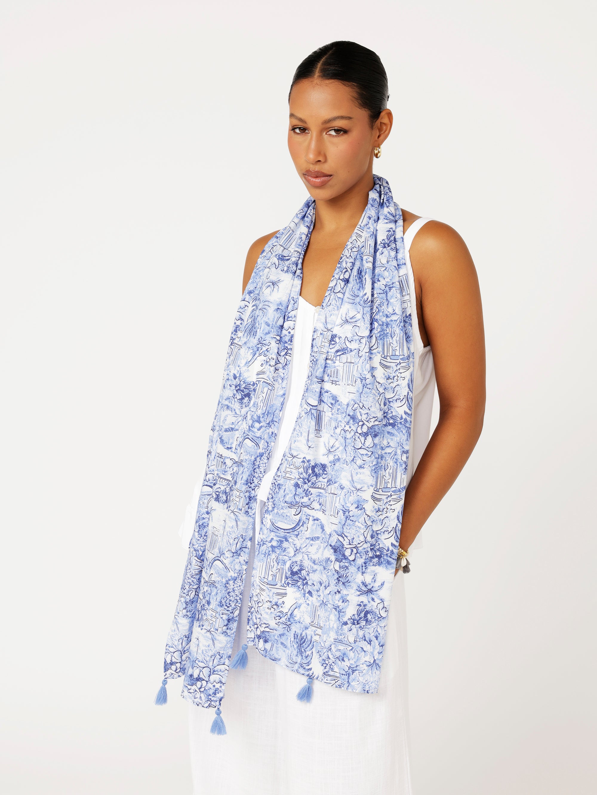 Front view of model wearing Lost City Blue Toile de Jouy rayon scarf draped loosely over white outfit