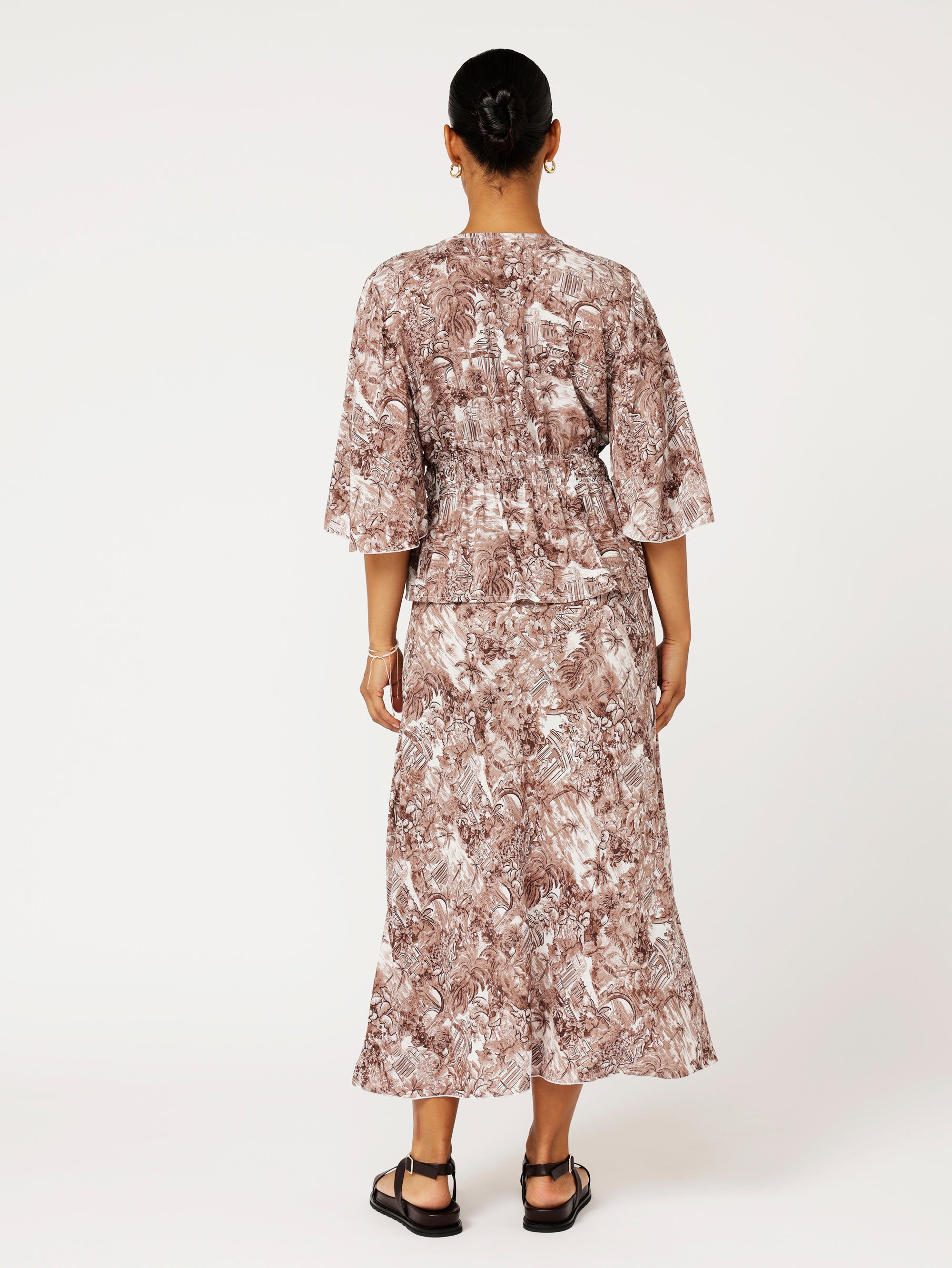 back view of model wearing the Violet Skirt in chocolate Toile de Jouy rayon print, styled with matching Thalia Top for a coordinated resort look