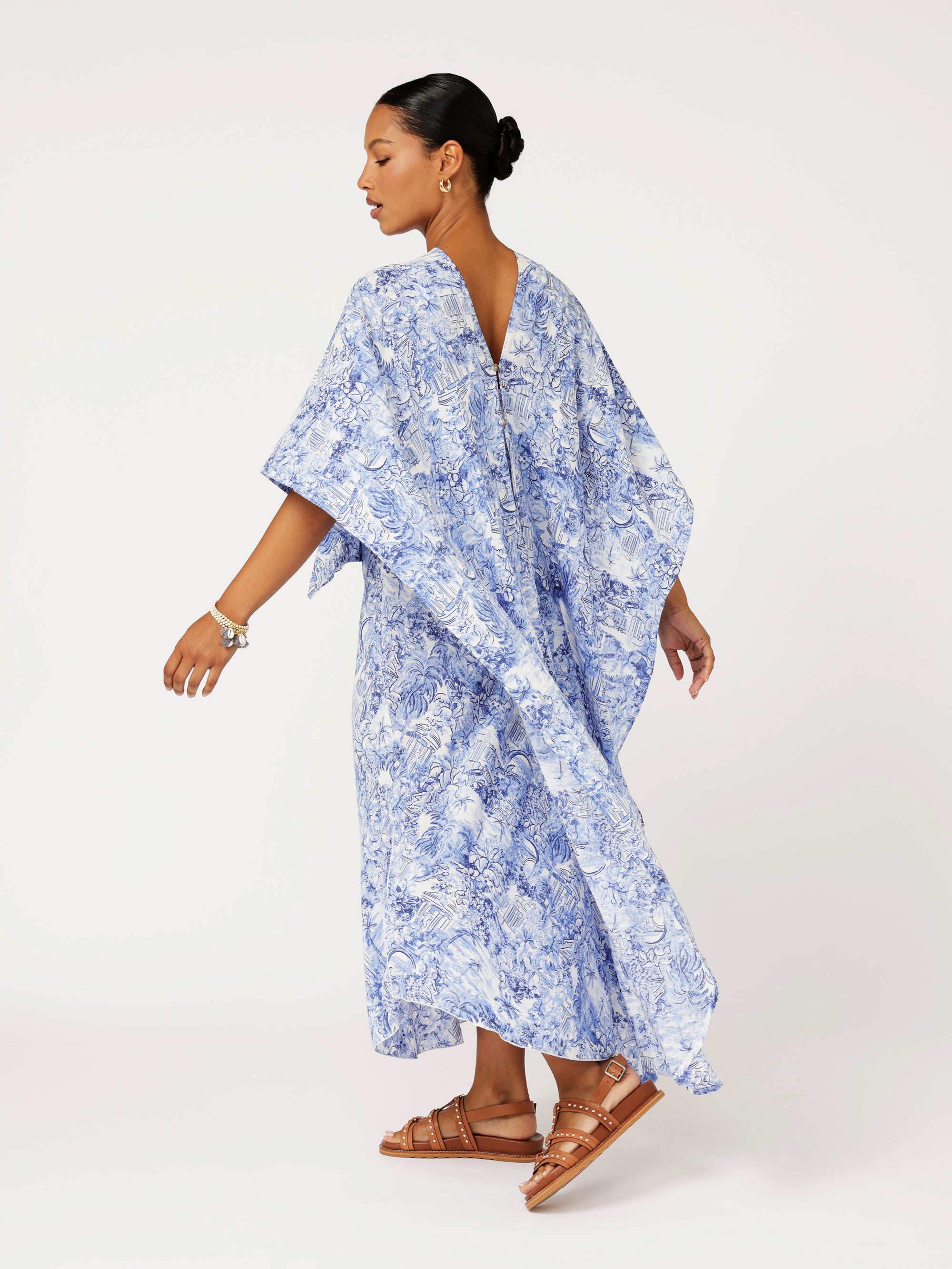 back view of model wearing Soiree Wrap in blue Toile de Jouy rayon print styled over matching Slip Dress for evening resort look.