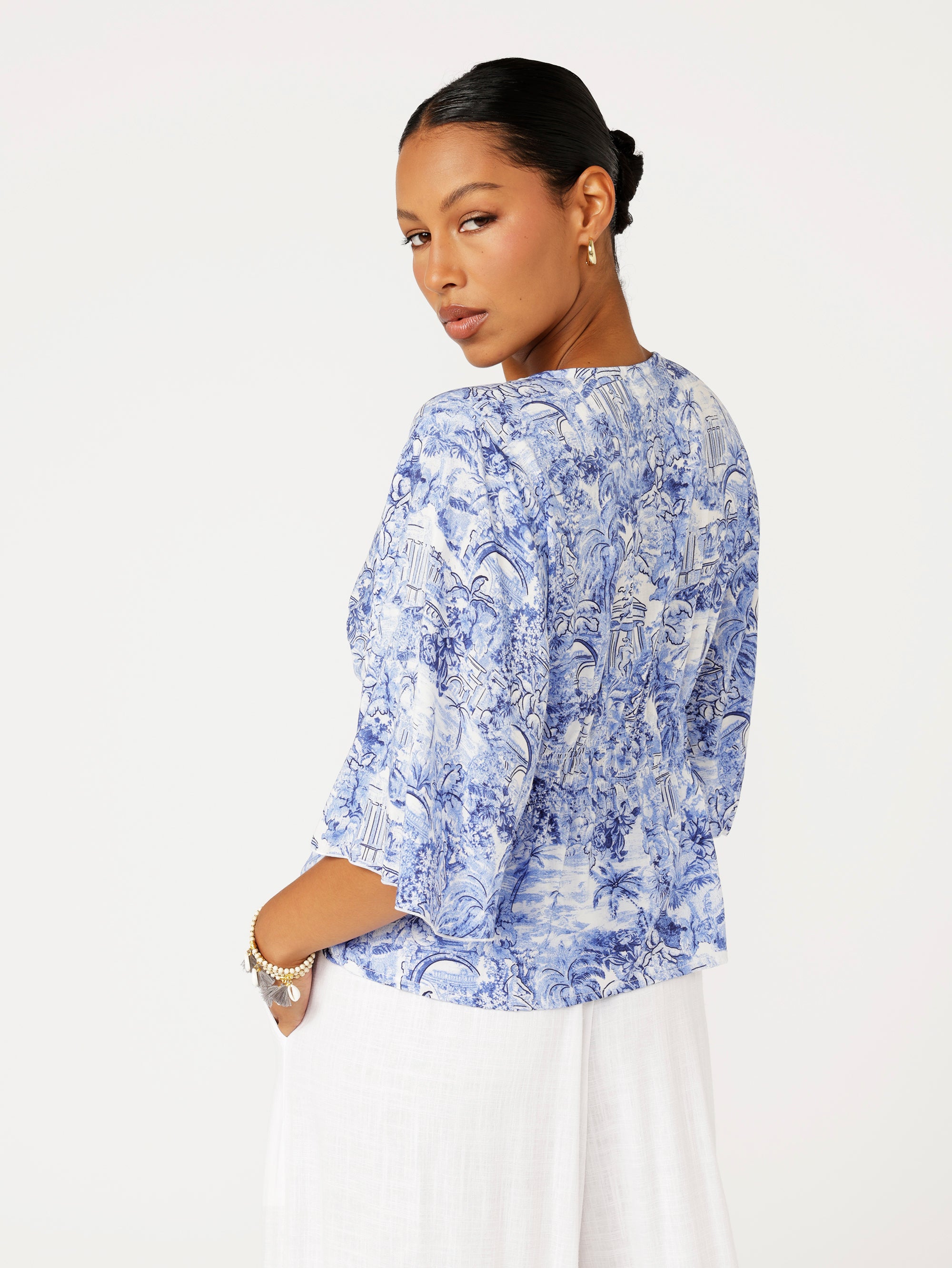 back view of model wearing ruched blue Toile de Jouy top in rayon fabric